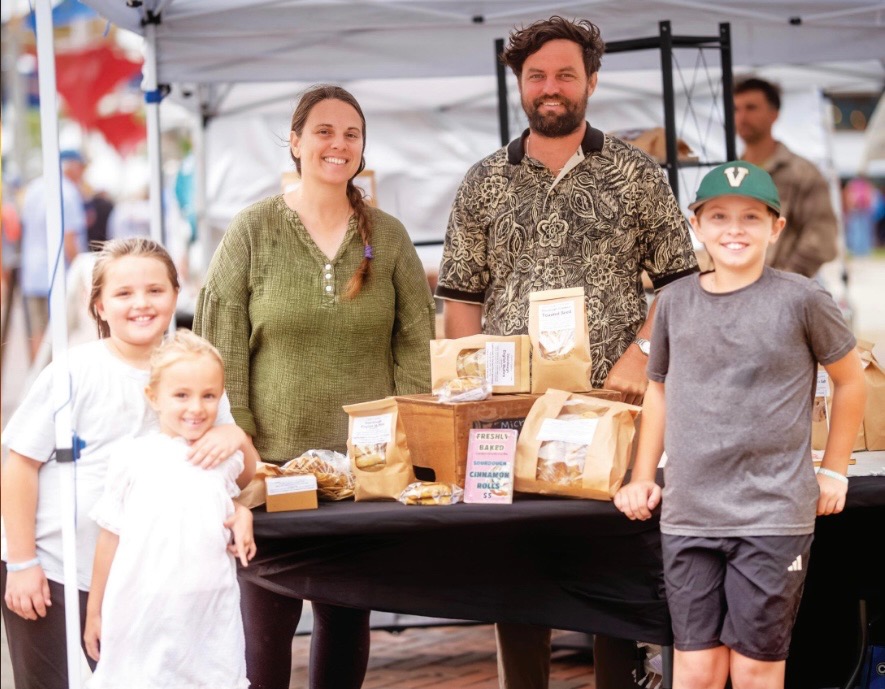 The Carlin family at their market stand with fresh baked bread and pastries